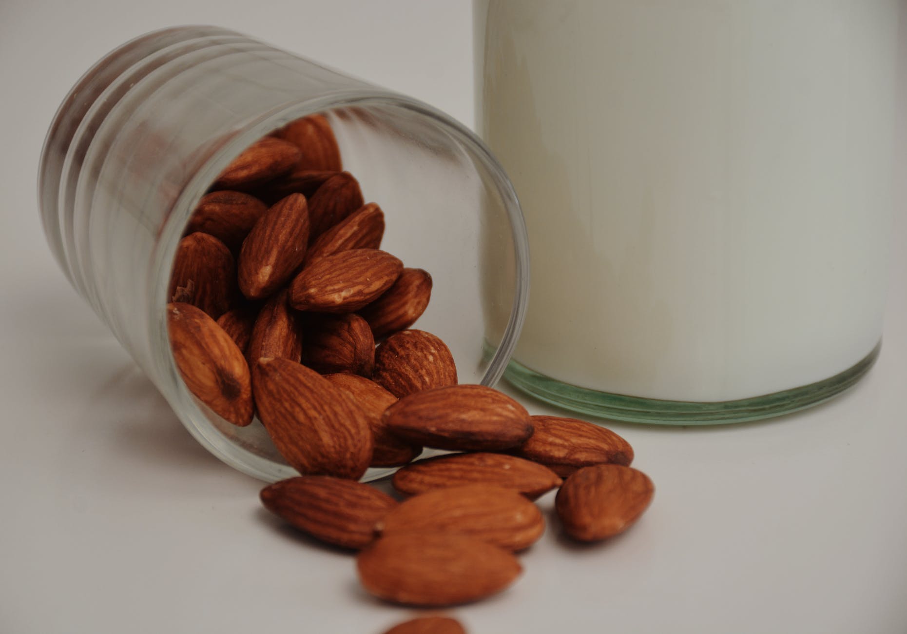 fallen glass with crunchy almonds near milk